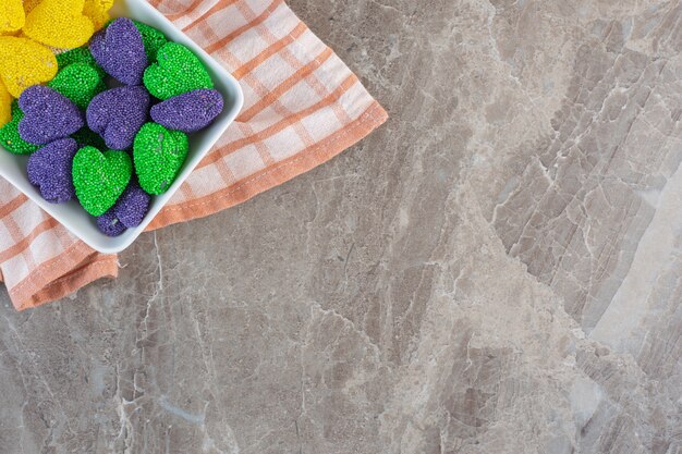 Vue de dessus des bonbons de la Saint-Valentin en forme de coeur à l'intérieur d'un bol sur une serviette.