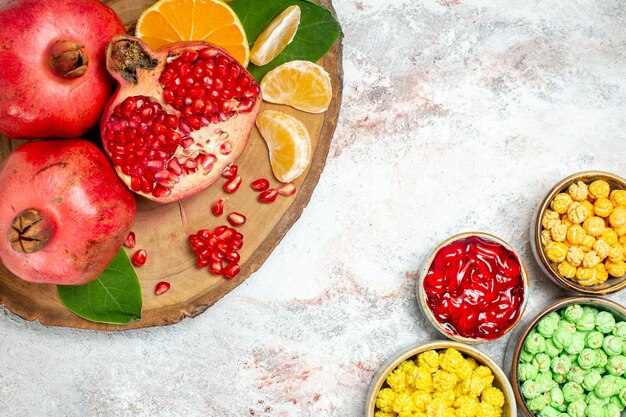 Vue de dessus des bonbons de sucre sucré avec des fruits frais sur fond blanc sucre candy fruit sweet