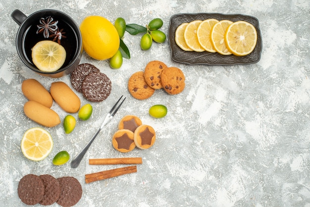 Vue de dessus des bonbons une tasse de thé à l'anis étoilé agrumes tranches de citron fourchette de biscuits appétissants