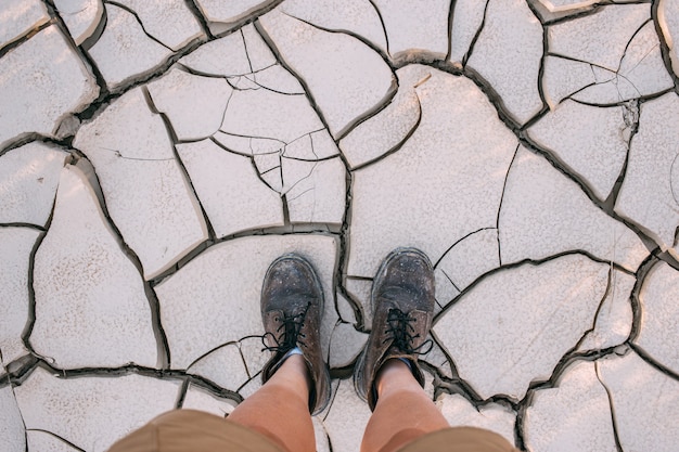 Photo gratuite vue de dessus sur des bottes en cuir sur terre sèche craquelée