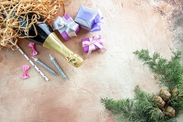 Vue de dessus bouteille de champagne avec petits cadeaux sur cadeau de couleur claire alcool photo fête du nouvel an