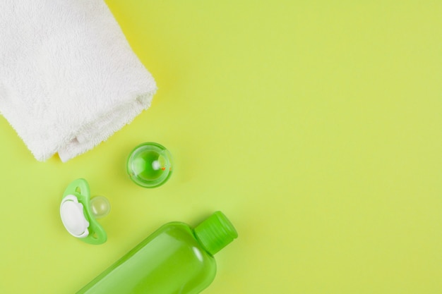 Vue de dessus de la bouteille d'huile avec serviette et tétine pour douche de bébé