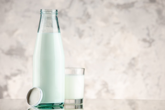 Vue de dessus de la bouteille en verre et de la tasse remplie de bouchon de lait sur fond de fumée blanche avec espace libre