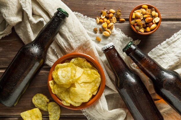 Vue de dessus des bouteilles de bière avec chips et noix