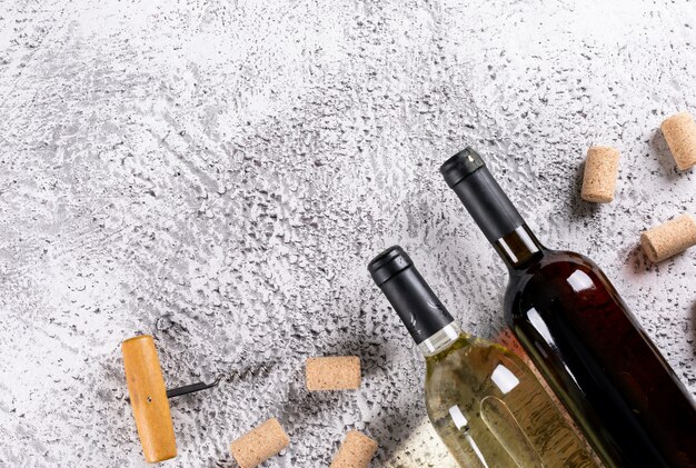 Vue de dessus des bouteilles de vin avec bouchons en liège et espace copie sur pierre blanche horizontale