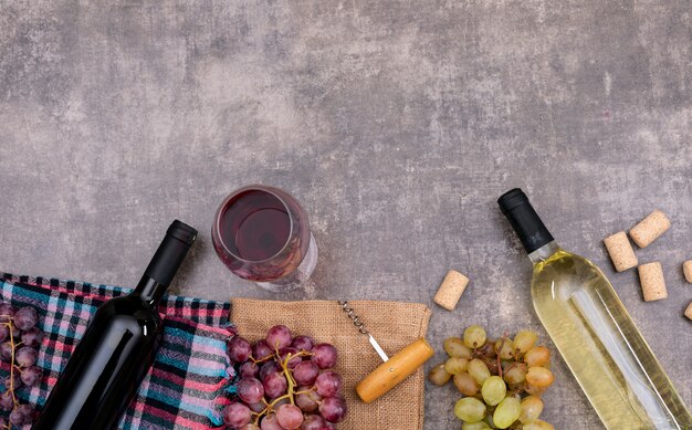 Vue de dessus des bouteilles de vin avec verre sur un sac et copie espace sur pierre sombre horizontale