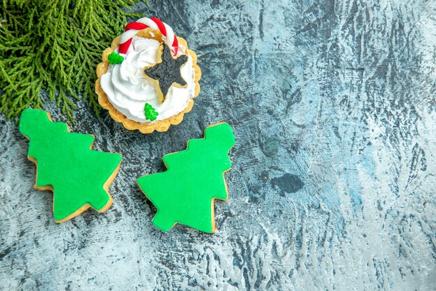 Vue de dessus de la branche de pin tarte de Noël biscuits d'arbre de Noël sur place libre de table grise