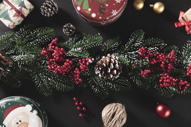 Vue de dessus de branches de pin avec cône et cadeau sur une table noire - concept de Noël