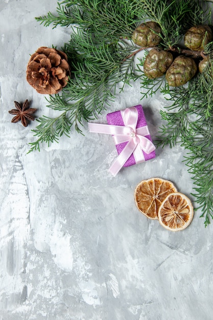 Vue de dessus des branches de pin petit cadeau des tranches de citron séchées sur une surface grise