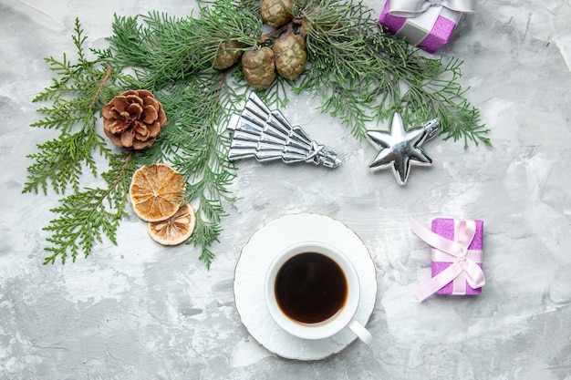 Vue de dessus des branches de pin tasse de thé tranches de citron séché pommes de pin petits cadeaux sur une surface grise