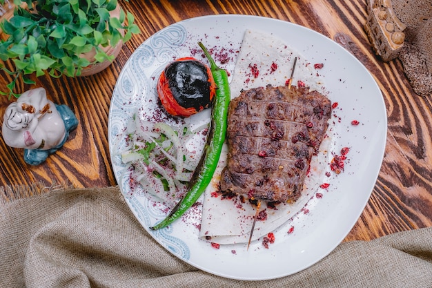 Vue de dessus brochette de côtes d'agneau sur pain pita avec oignons et légumes grillés