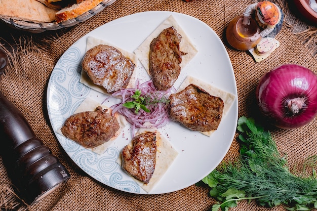 Vue de dessus brochette de foie de veau sur pain pita aux oignons et herbes