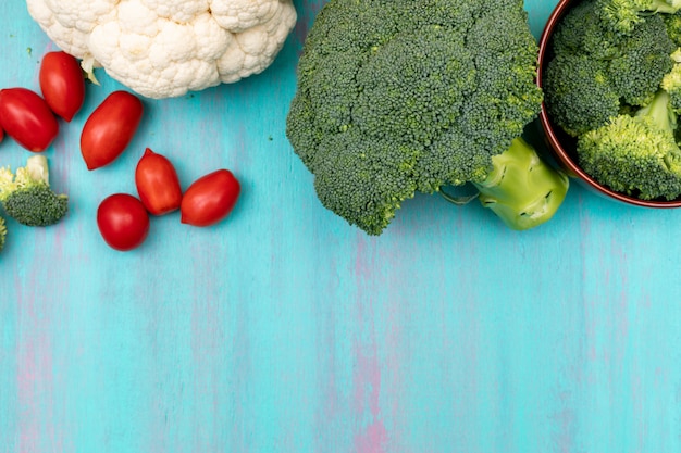 Vue de dessus de brocoli de chou-fleur et tomate cerise avec copie espace sur la surface bleue