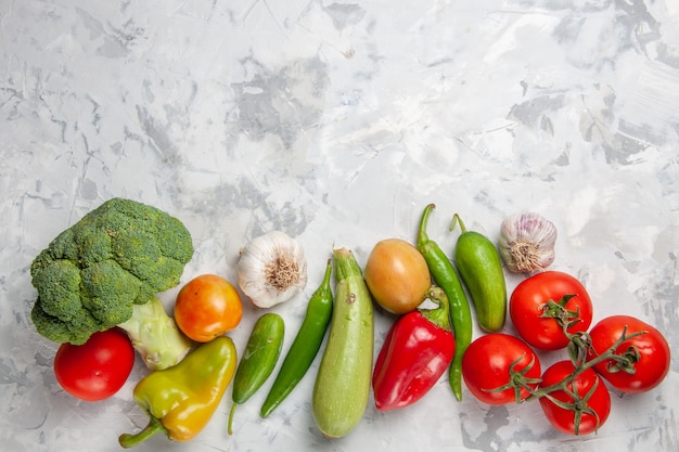 Vue de dessus brocoli vert frais avec des légumes sur une salade de table blanche régime santé mûr