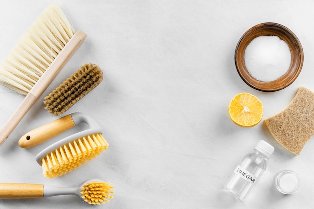 Vue de dessus des brosses de nettoyage avec du bicarbonate de soude et du citron