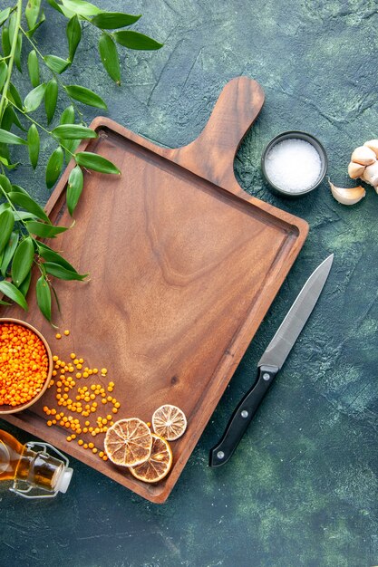 Vue de dessus bureau en bois brun avec des lentilles orange sur la surface bleu foncé cuisine ancienne couleur viande boucher couteau de cuisine alimentaire