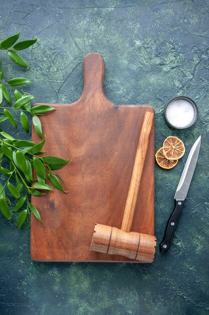 Vue de dessus bureau en bois brun avec marteau sur la surface bleu foncé cuisine en bois de couleur brun vif cuillère d'arbre couverts