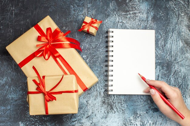 Vue de dessus des cadeaux de Noël attachés avec des arcs rouges sur fond clair-foncé