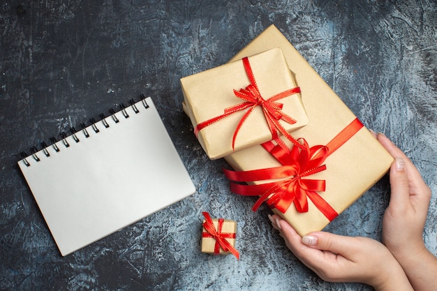 Vue de dessus des cadeaux de Noël attachés avec des arcs rouges sur fond clair-foncé