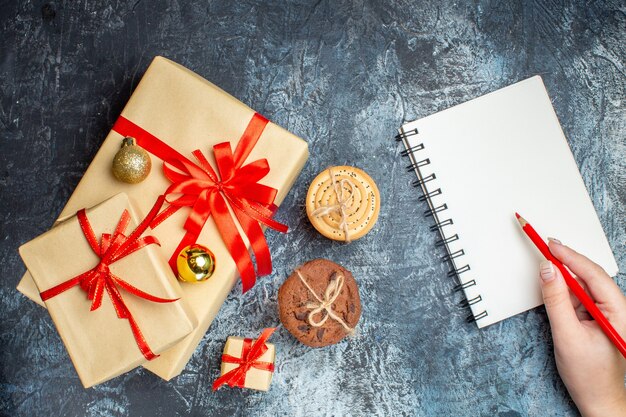 Vue de dessus des cadeaux de Noël avec des biscuits sur fond clair-foncé