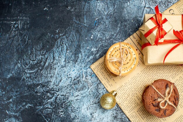 Vue de dessus des cadeaux de Noël avec des biscuits sur fond clair-foncé