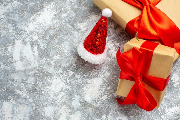 Vue de dessus des cadeaux de noël bonnet de noel sur une table blanche grise place libre