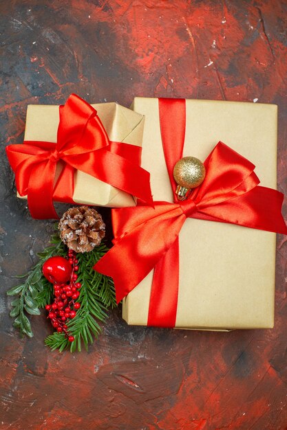 Vue de dessus des cadeaux de Noël branche d'arbre de Noël sur une table rouge foncé