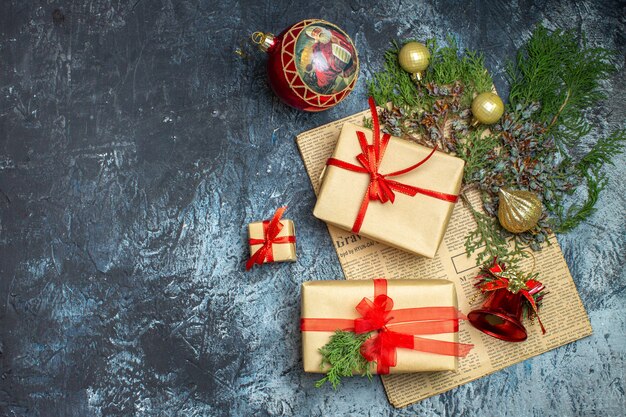 Vue de dessus des cadeaux de Noël avec une branche verte sur une photo de bureau clair-foncé couleur de Noël du nouvel an