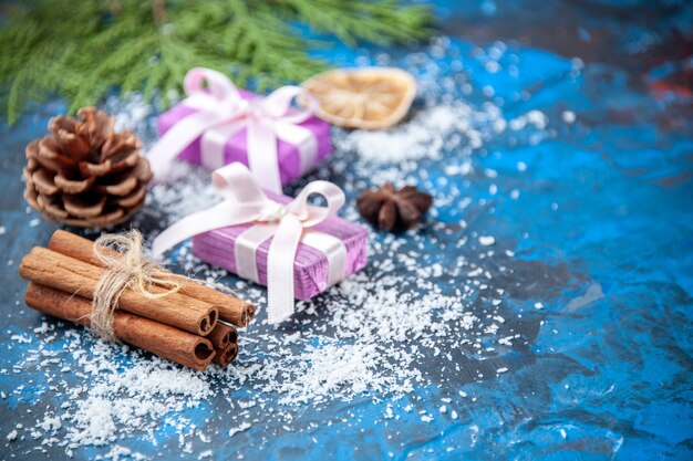 Vue de dessus cadeaux de noël branches de sapin cônes anis sur surface bleue