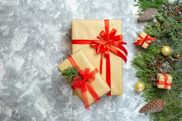 Vue de dessus des cadeaux de noël emballés avec des arcs rouges et un arbre sur un cadeau de photo de vacances de couleur de noël blanc nouvel an