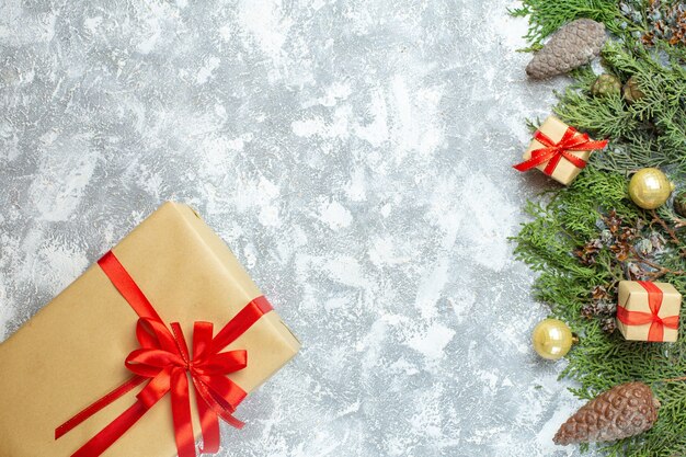 Vue de dessus des cadeaux de noël emballés avec des arcs rouges et un arbre sur un cadeau de photo de vacances de couleur de noël blanc nouvel an