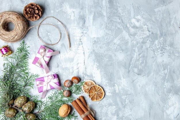 Vue de dessus cadeaux de Noël fil de paille bâtons de cannelle sur fond gris