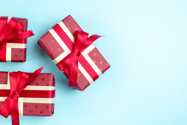 Vue de dessus des cadeaux de la Saint-Valentin avec un arc rouge sur la surface bleue couleur de couple je t'aime cadeau photo sentiment de parfum d'amour