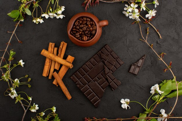 Vue de dessus café chocolat cannelle avec des fleurs blanches sur le noir