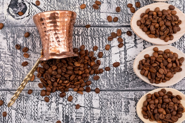 Vue de dessus de café en grains de café et des cuillères en bois sur une surface en bois