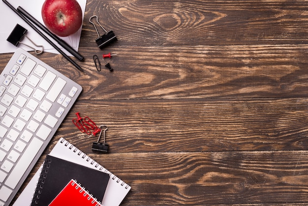 Vue de dessus des cahiers et pomme sur un bureau en bois avec espace copie