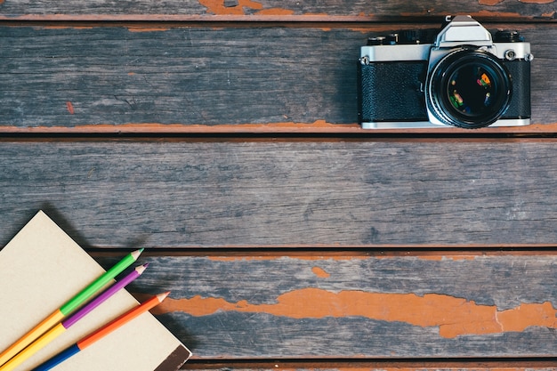 Vue de dessus de la caméra vintage, le cahier et le crayon de couleur