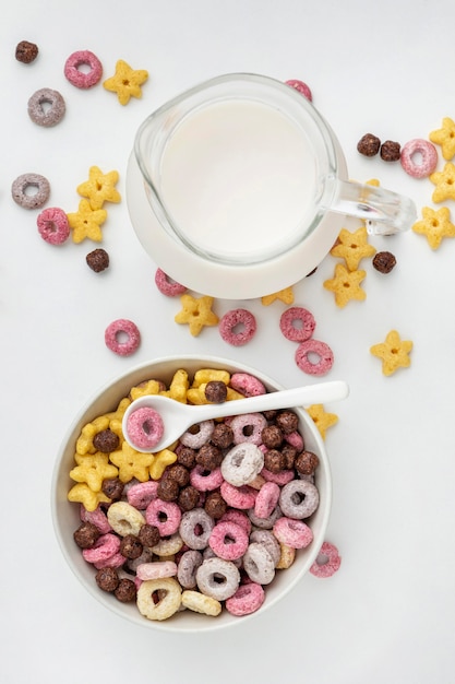 Vue de dessus des céréales de petit-déjeuner multicolores de différentes formes avec du lait