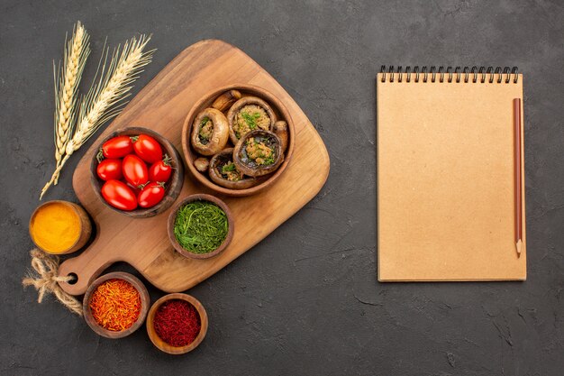 Vue de dessus champignons cuits avec assaisonnements sur table sombre champignon alimentaire mûr