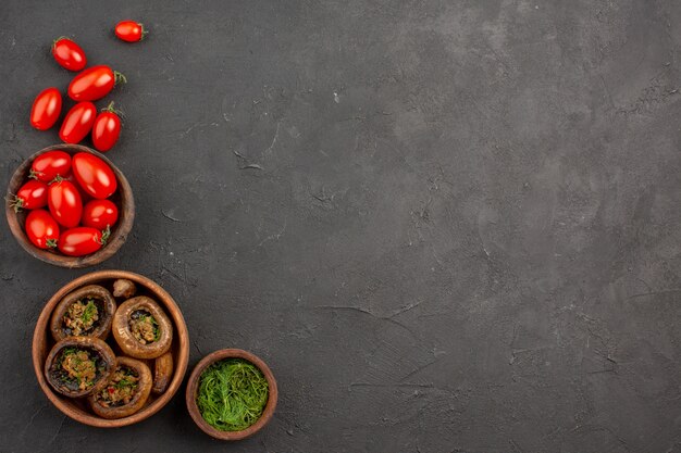 Vue de dessus champignons cuits aux tomates sur les pâtes sauvages aux champignons de table noir