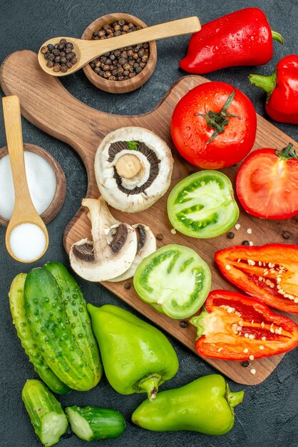 Vue de dessus des champignons de légumes frais coupés des tomates rouges et vertes sur un tableau noir