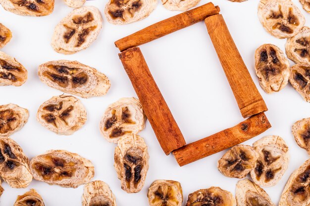 Vue De Dessus Des Chips De Banane Séchée Avec Des Bâtons De Cannelle Sur Fond Blanc