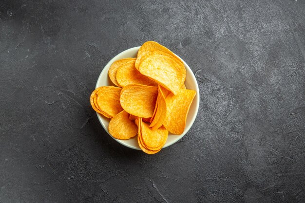 Vue de dessus des cips au fromage à l'intérieur de la plaque sur fond sombre