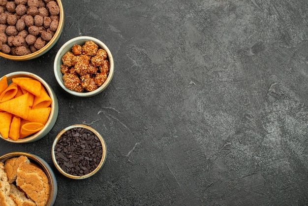 Vue de dessus des cips orange avec des noix sucrées et des flocons de chocolat sur une surface grise collation collation petit-déjeuner noix