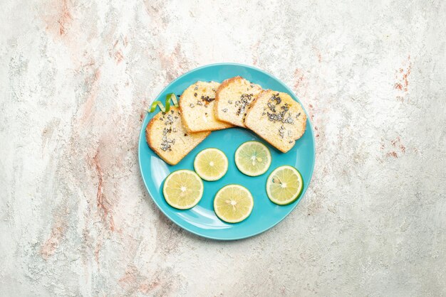 Vue de dessus citron tranché citron tranché et pain blanc dans la plaque bleue au centre de la table