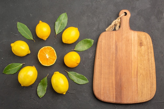 Vue de dessus citrons aigres frais bordés sur table sombre agrumes jaune citron vert