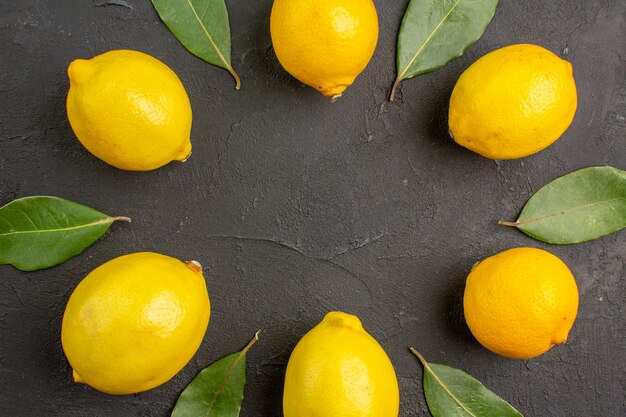 Vue de dessus citrons aigres frais bordés sur table sombre, citron vert citron vert