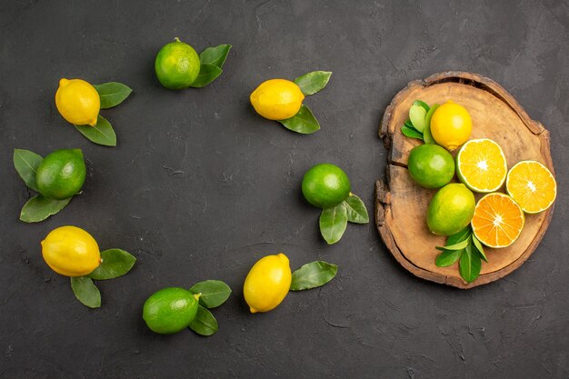 Vue de dessus citrons aigres frais sur la table gris foncé citron vert citron