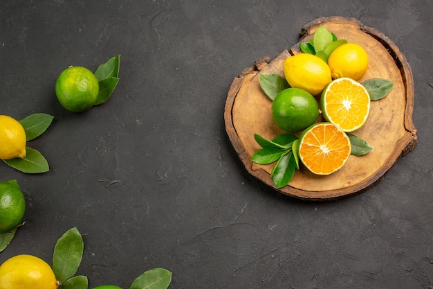 Vue de dessus citrons aigres frais sur la table gris foncé fruits agrumes citron vert