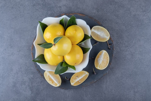 Vue de dessus des citrons biologiques frais et des tranches sur planche de bois.